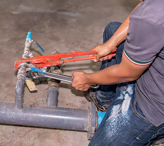 Licensed plumber repairing a copper pipe leak in a Idaho basement